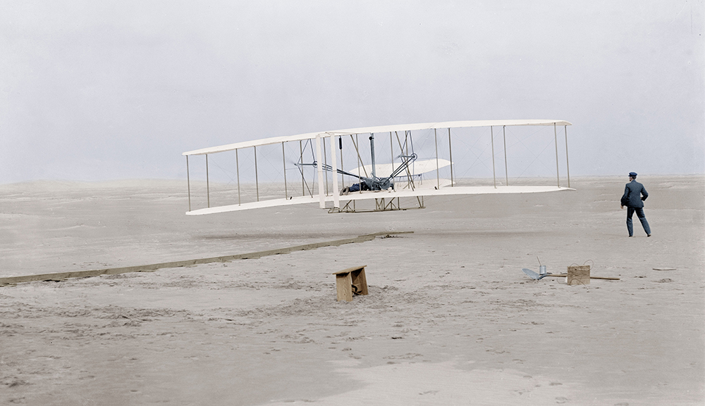 L'aviateur Orville Wright (1871-1948) avec son avion biplan Flyer sur la plage de Kill Devil Hills a Kitty Hawk, Caroline du Nord, lors de son 1er vol le 17 decembre 1903 sur une distance de 120 pieds (36,5 metres) pour une duree de 12 secondes, son frere Wilbur Wright se tient debout a droite de l'appareil --- first flight of Orville Wright (1871-1948) at Kill Devil Hills, Kitty Hawk, North Carolina december 17, 1903 (120 feet in 12 seconds), his brother Wilbur Wright stand on the right