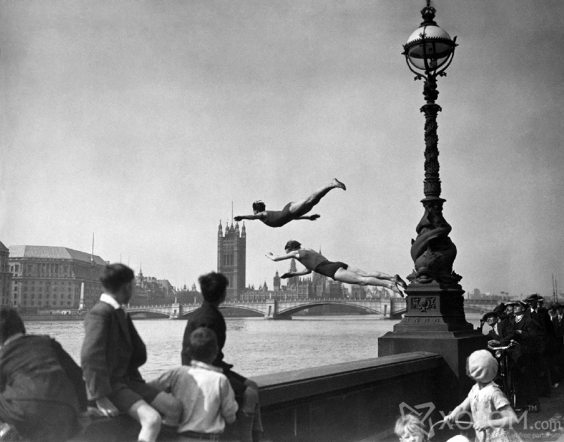 Two divers jumping off the Embankment into the River Thames in London, near Westminster Bridge. (Photo by H F Davis/Getty Images)