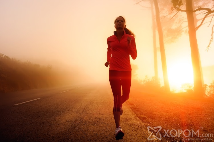 Healthy running runner woman early morning sunrise workout on misty mountain road workout jog. sunflare through the mist gives atmospheric feel and depth to these fitness images; Shutterstock ID 103383071; PO: aol; Job: production; Client: drone